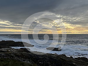 Sunset through the clouds over the rocky coast of Atlantic Ocean, A Guarda, Galicia, Spain, December 2022