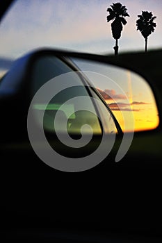 Sunset clouds reflected car mirror