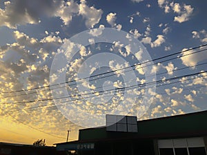 Sunset cloudy sky with picturesque clouds lit by warm sunset sunlight. Country road at sunset