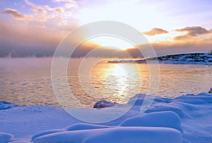 Sunset and cold fog spreads over freezing northern sea