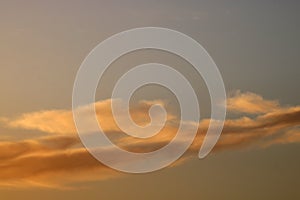 Sunset colored clouds in blue sky for background