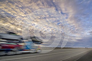 Sunset colors over interstart with eighteen wheeler