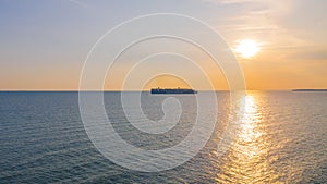 During sunset a Container cargo ship arriving in the harbor