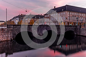 Sunset in Copenhagen on an old canal with boats and houses reflecting in the calm waters - 9