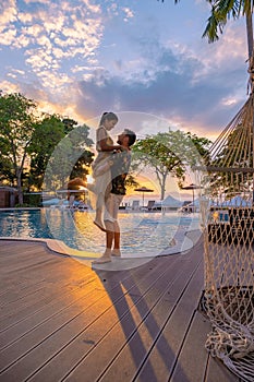 Sunset on Cosy Beach Pattaya Thailand , couple man and woman watching sunset by the pool in Pattaya Thailand