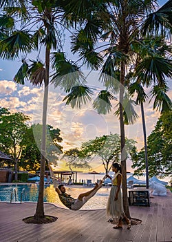 Sunset on Cosy Beach Pattaya Thailand , couple man and woman watching sunset by the pool in Pattaya Thailand