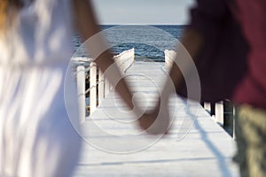 A couple walking on a white pier, during sunset photo