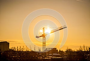 Sunset through a crane in industrialized area of city