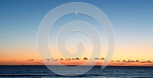 Sunset crescent moon overhead ocean sea water landscspe