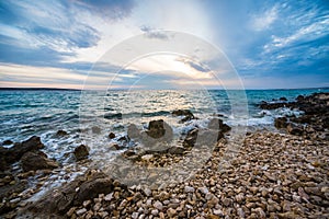 Sunset on croatian stony beach