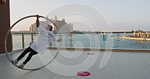 Sunset in Dubai, Atlantis hotel and the sea, young man doing wheel gymnastics 4k