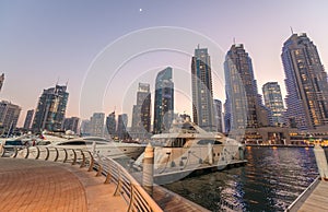 Sunset in Dubai Marina. Buildings reflections over artificial ca