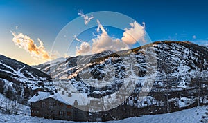 Sunset at El Tarter village with clouds and mountains illuminated by sunlight and valley in shadow., Andorra