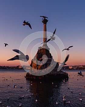 Sunset on embankment of Sevastopol. Monument to sunken ships against the sun. Sevastopol, Crimea