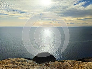 Sunset on the empty rocky shore. A cliff above the sea. Cyprus, Mediterranean coast. Marine landscape in soft palette.