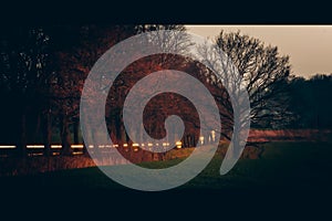 Sunset on fields and road, long exposure, blurry car lights