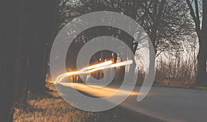 Sunset on fields and road, long exposure, blurry car lights