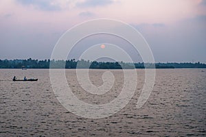 Sunset with fishing boat at the Ashtamudi Lake, Kollam, Kerala, India