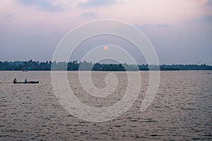 Sunset with fishing boat at the Ashtamudi Lake, Kollam, Kerala, India photo