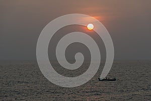 Sunset and fishing boat seen from Anjuna Beach,Goa,India