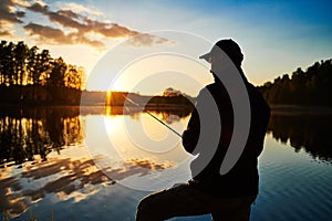 Sunset fishing. fisher with spinning rod