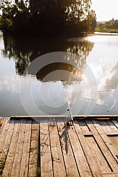 sunset fishing. fisher with spinning rod. Fisherman with rod, spinning reel on the river bank. Fishing for pike, perch