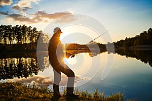 Sunset fishing. fisher with spinning rod