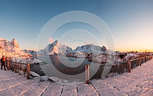 Sunset on fishing village with snowy mountain at Reine