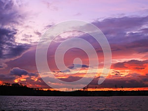 Sunset with flaming horizon in the countryside and view on the water