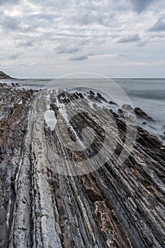 Sunset at the Flysch geological coastline, with Flysch formations in Zumaya in the Basque Country, Spain photo