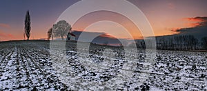 Sunset on frozen field with a chapel.