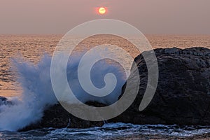 Sunset in Galle in Sri Lanka with a wave.