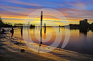 Sunset glow over the river and beach, with smooth water surface