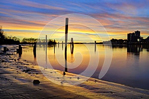 Sunset glow over the river and beach, with smooth water surface