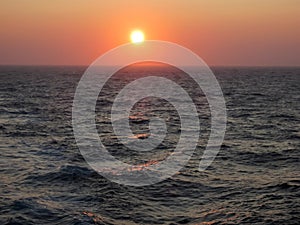 Sunset Glows Orange over Rough Ocean Surface