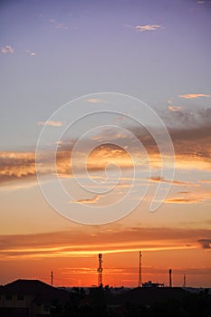 Sunset golden hour with silhouettes of buildings and towers and magnificent cloud paintings