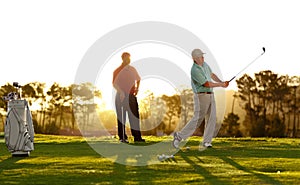 Sunset, golf and men on a course for training, competition or professional game. Fitness, summer and friends on the