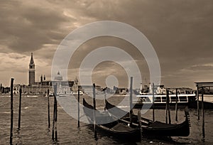 At sunset a Gondolas parking is a traditional, flat-bottomed Venetian rowing boat,