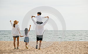 Sunset happiness at the sea beach, A family of four with raised arms enjoying