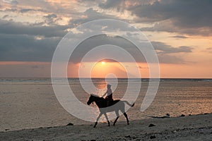 Sunset Harmony: Man and Horse Aligned with Gili Trawangan Twilight