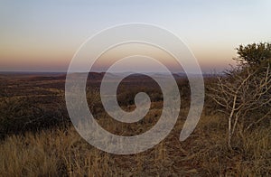 Sunset from a hill looking down over the hills and plains below at the Madikwe Game Reserve