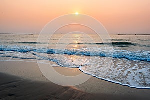 Sunset at horizontal tropical sea beach with wave reaching shore