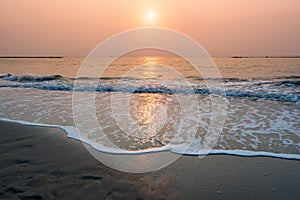 Sunset at horizontal tropical sea beach with wave reaching shore