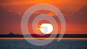 Sunset. Huge sun. Beautiful seascape. Red sky with clouds. Ocean or Gulf of Mexico. Summer vacation. Sundown Horizon Panorama