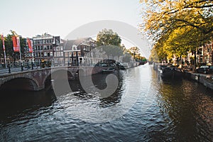Sunset illuminates a water canal and adjacent buildings in the capital city of Amsterdam, the Netherlands