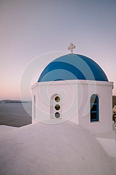 Sunset at the Island Of Santorini Greece, beautiful whitewashed village Oia with church and windmill during sunset