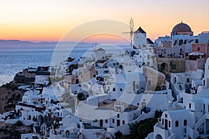 Sunset at the Island Of Santorini Greece, beautiful whitewashed village Oia with church and windmill during sunset