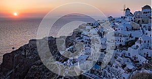 Sunset at the Island Of Santorini Greece, beautiful whitewashed village Oia with church and windmill during sunset