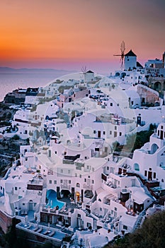 Sunset at the Island Of Santorini Greece, beautiful whitewashed village Oia with church and windmill during sunset