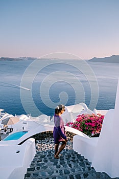 Sunset at the Island Of Santorini Greece, beautiful whitewashed village Oia with church and windmill during sunset Woman